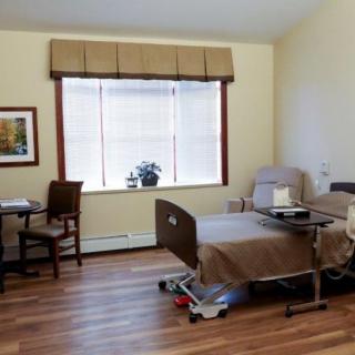 A hospital room with a bed, chair, and window, creating a comfortable healthcare environment.