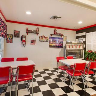 A retro-style diner with red chairs and checkered flooring.