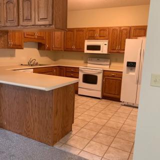 A cozy kitchen with wooden cabinets and modern appliances.