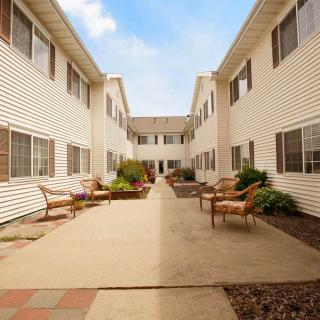 A peaceful residential courtyard featuring benches and landscaped pathways.