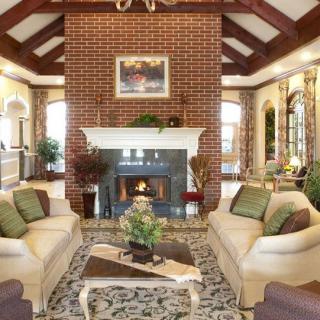 A cozy living room with a brick wall, elegant fireplace, and comfortable sofas.