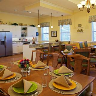 A cozy dining area with a neatly set table and an open view into the kitchen.