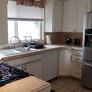 A modern kitchen with white cabinets and stainless steel appliances.