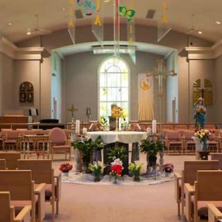 Interior view of a church, featuring an altar and rows of pews.