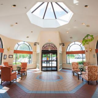 A bright and welcoming lobby with comfortable seating and a skylight, designed for relaxation.