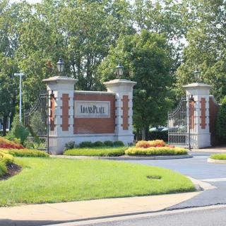 Entrance gates with brick columns and greenery.