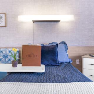 A modern and cozy hotel room featuring blue bedding and stylish decor.
