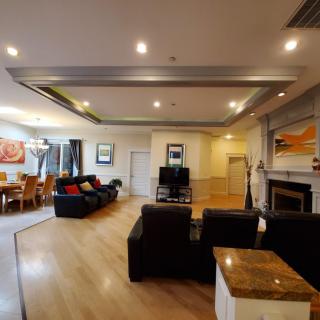 A spacious and modern living room featuring a comfortable seating area, a dining space, and elegant interior design elements.