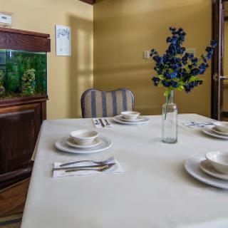 A beautifully arranged dining table with elegant tableware and a floral centerpiece.
