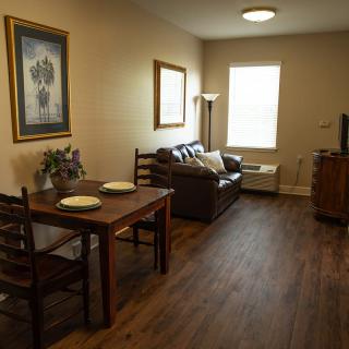 A cozy living room with a dining area and a sofa facing a television.