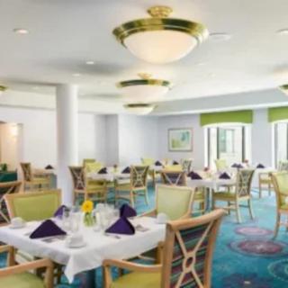 A well-decorated dining room with neatly arranged tables and elegant lighting fixtures.