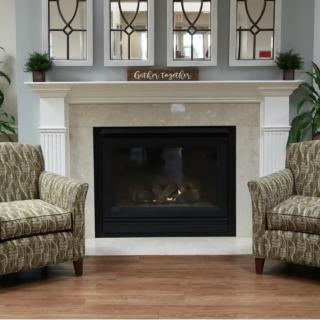 A cozy living room with a fireplace, flanked by patterned armchairs and decor elements.