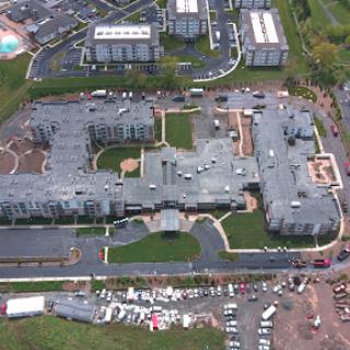 An aerial view of a residential complex featuring multiple buildings and landscaped areas.