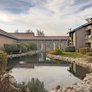 A scenic view of apartment buildings with a central pond and landscaped surroundings.