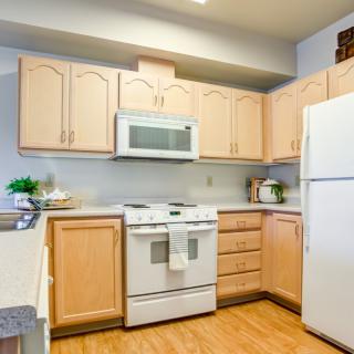 Modern kitchen with light wood cabinets and appliances