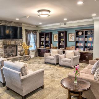 A cozy and well-designed living room with comfortable seating, a fireplace, and bookshelves.