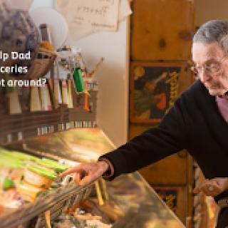An elderly artist engages with their work, surrounded by various art supplies and tools.