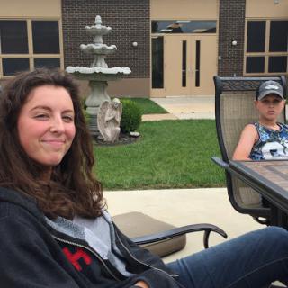 Two individuals enjoying a relaxed moment outdoors by a fountain.
