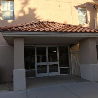 The entrance of a contemporary building with a tiled roof.