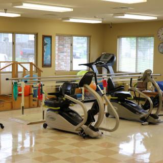 A well-equipped physical therapy room featuring various exercise machines and rehabilitation tools.