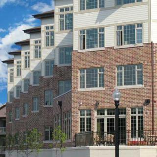 A modern residential building with brick exterior and large windows.