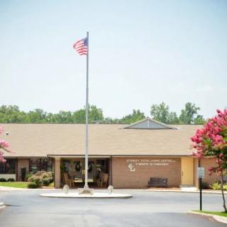 A single-story brick building with an American flag flying on a pole in front.