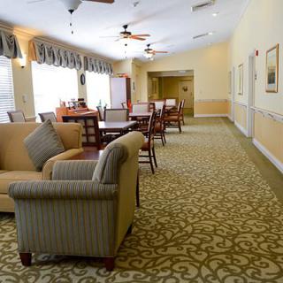 A cozy living area with comfortable seating, tables, and large windows allowing natural light.