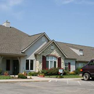 A residential house with a stone facade and a parked vehicle in the driveway.