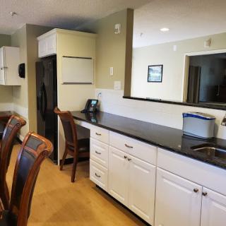 A spacious and modern kitchen featuring sleek black countertops and bright cabinetry.