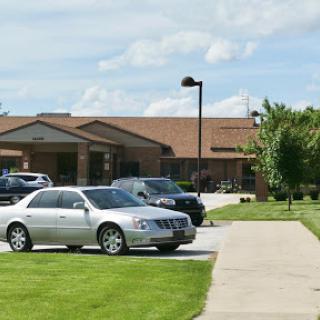 A view of a parking lot in front of a building on a sunny day.