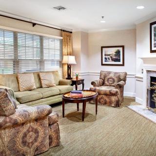 A cozy living room with a sofa, armchairs, and a fireplace.