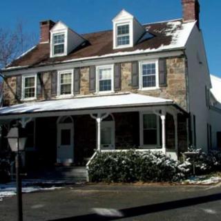 A two-story residential house with snow on the roof and surrounding area.