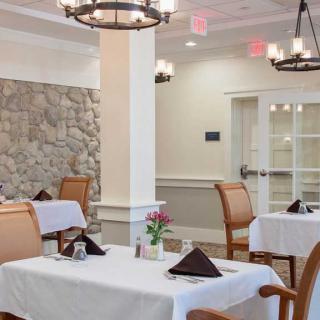 An elegant dining room with neatly set tables and comfortable chairs.