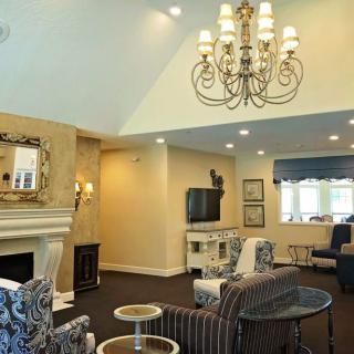 A cozy living room with elegant furnishings and a grand chandelier.