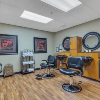 A modern salon interior with styling chairs, mirrors, and vibrant artwork on the walls.