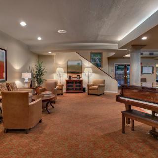 A cozy living room with a piano and comfortable seating.