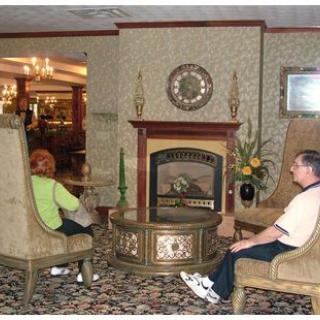 Two people sitting in a hotel lobby with a fireplace and elegant decor.