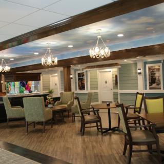 A modern cafe interior with various seating options and elegant chandeliers.