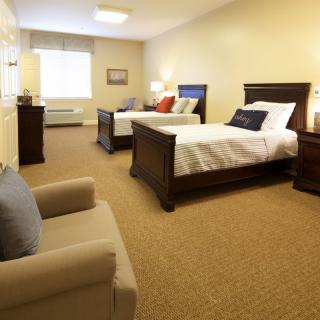A tidy hotel room featuring two beds and cozy furnishings.