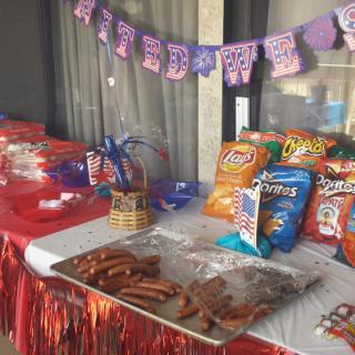 A festive table setup with a variety of snacks and sausages, adorned with a colorful birthday banner.