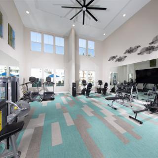 A modern gym with various exercise equipment and a spacious interior.