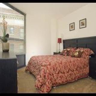 Cozy bedroom with a patterned comforter and large window.
