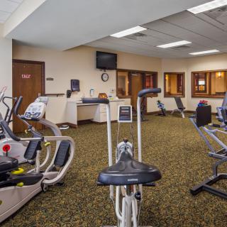 A spacious gym with various exercise equipment including stationary bikes.