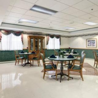 A formal dining area with neatly arranged tables and chairs, adorned with elegant curtains and decorations.