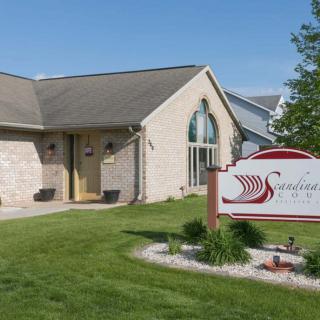 A clinic with a well-maintained lawn and a prominent sign, set on a sunny day.