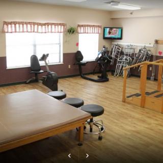 A well-equipped physical therapy room with exercise machines and rehabilitation tools.