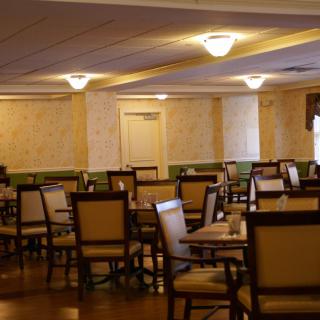 An empty restaurant dining area with neatly arranged tables and chairs.