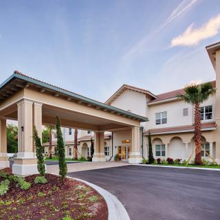 A modern building with a covered entrance and well-maintained landscaping.