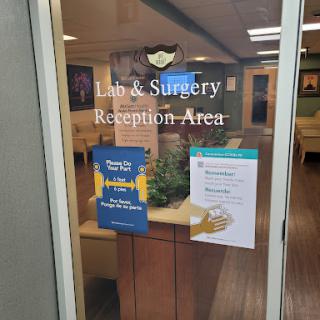 The entrance to a lab and surgery reception area with informative signage.