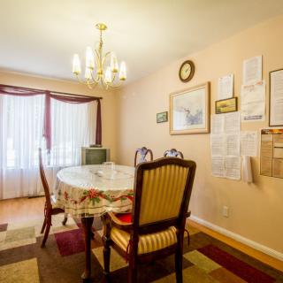 A cozy dining room with a table set, chandelier, and wall decorations.